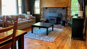 L’intérieur d’un chalet accueillant, avec un plancher en bois, un canapé, une table basse et une cheminée.