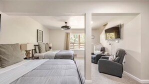 A hotel room with two beds, a desk, a chair, a TV, and a window with a view of the outdoors. - Tahoe Mountain Escape. 12 Min to Beach (Stateline)