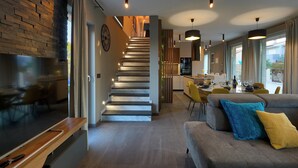 A modern living room with a staircase, a dining area, and a kitchen. - Villa Bavigo - Luxury Spa Oasis (Marcana)