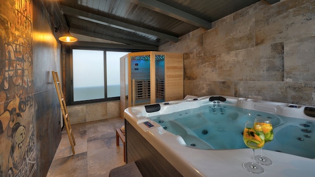 A modern spa area with a hot tub, wooden benches, and a glass-enclosed sauna. - Villa Bavigo - Luxury Spa Oasis (Marcana)