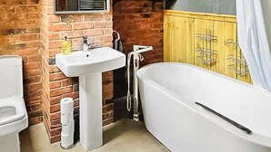 A bathroom with a white sink, a bathtub, and a yellow cabinet. - 5 bedroom accommodation in Grantham (Grantham)