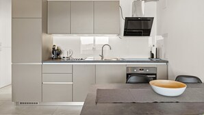 A modern kitchen with a built-in oven, a microwave, and a sink. There is a dining table with a bowl and a placemat. - Sea View Vacation at Apartment Jana - Cres Island (Cres)