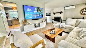 Una sala de estar moderna con televisor de pantalla plana, chimenea y una zona de estar acogedora.
