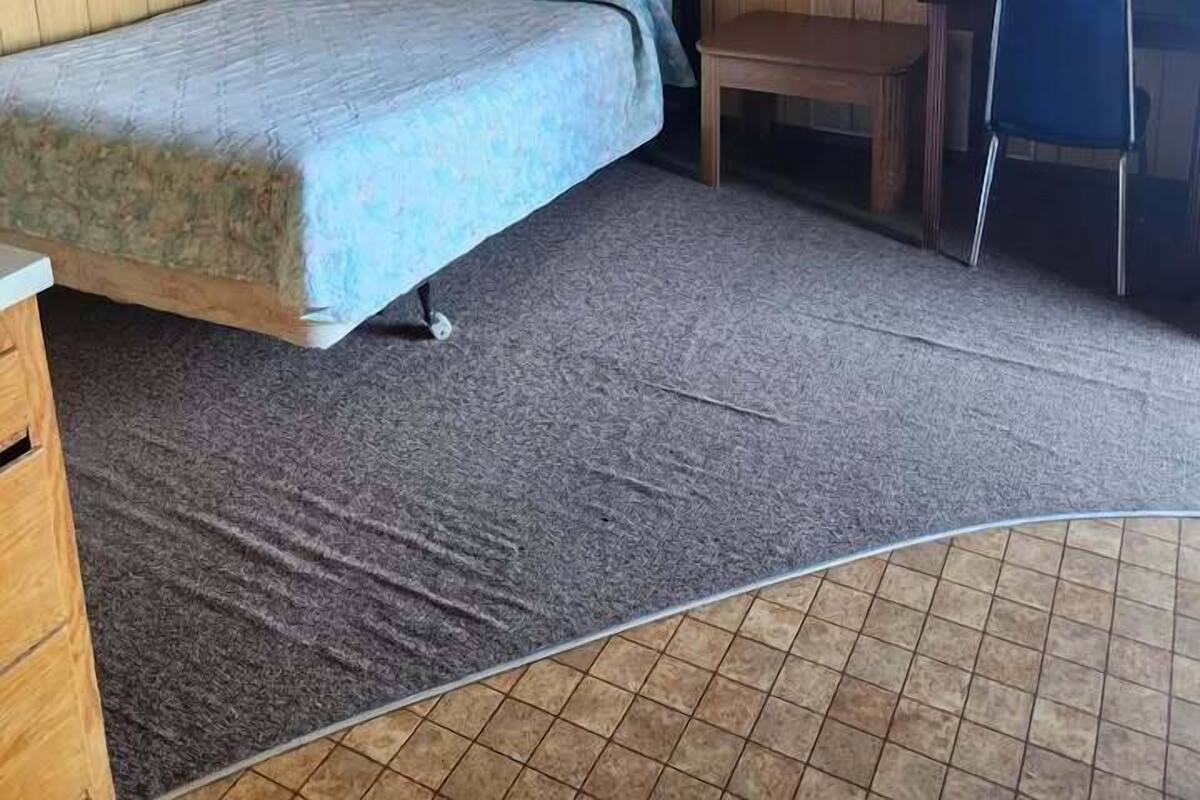 A room with a bed, a desk, and a chair.