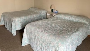 A room with two single beds, a small bedside table with a lamp, and a framed picture on the wall. - GULL LAKE LODGE MOTEL (Gull Lake)