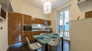 Una cocina moderna con una mesa de comedor, sillas y una araña.