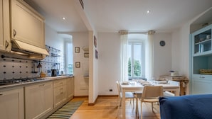 Une cuisine moderne avec un coin repas, un plancher en bois et une vue sur la verdure environnante.