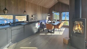 Una cocina moderna con una isla grande, paredes de madera y vistas a un lago.