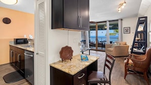 Un espace de vie compact comprenant une cuisine, un coin repas et un balcon avec vue.