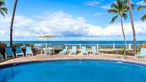 Une piscine avec des chaises longues et vue sur l’océan.