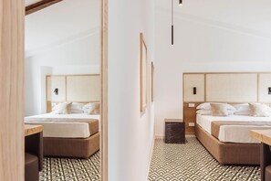 A hotel room with two beds, a wooden headboard, a patterned floor, and a small table.