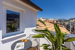A balcony with a table, two chairs, and a magazine titled "Living".