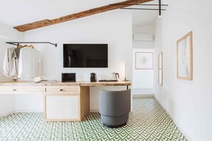 A modern room with a wooden desk, a television, and a patterned floor.