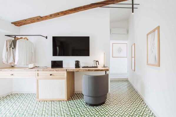 A modern room with a wooden desk, a television, and a patterned floor.