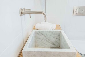 A bathroom with a marble sink, a wooden countertop, and a wall-mounted faucet. - Exclusive Suite with Terrace by Sorrento main Square (Sorrento)