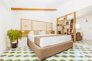 Een slaapkamer met een groot bed, een houten hoofdbord, een boekenkast en een geruite vloer.