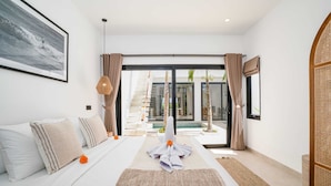 A modern hotel room with a large bed, a view of the pool, and a balcony. - Villa Flambard (Canggu)