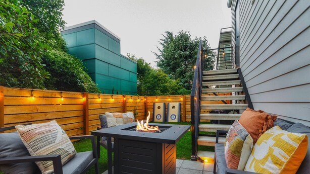 An outdoor patio with a fire pit, seating, and a staircase leading to a building. - Travelers Dream-Steps to Space Needle- Shared Backyard (Seattle)