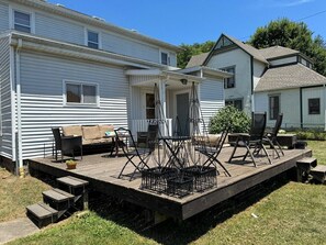 Ein Mobilheim mit einer Terrasse, die Gartenmöbel und einen Tisch bietet.