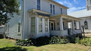 A two-story house with a porch and a small garden area.