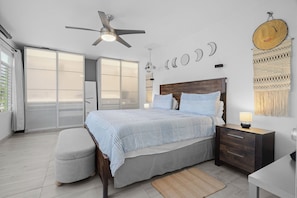 A bedroom with a bed, nightstand, and a ceiling fan.