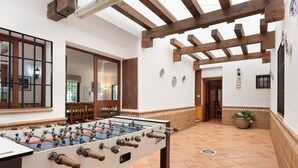 A foosball table in a room with wooden beams, tiled floor, and a potted plant. - Country House 'Casa Rural Salrima' with Mountain View, Wi-Fi and Air Conditioning (Alora)