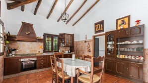Una cocina con armarios de madera, una mesa de comedor y un horno empotrado.