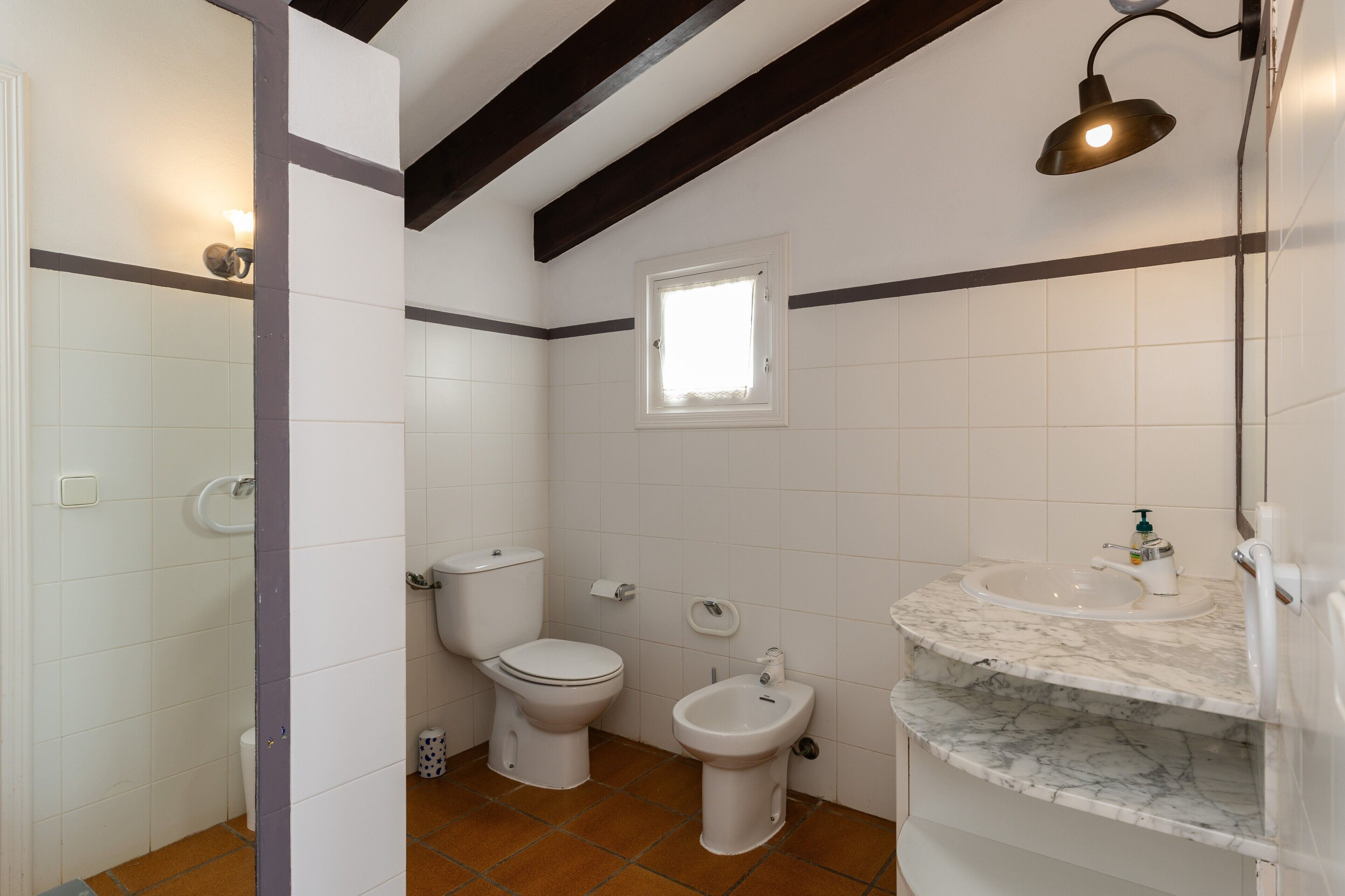 A bathroom with a toilet, bidet, and sink.