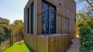 Un edificio moderno de madera con ventanas amplias y un balcón.