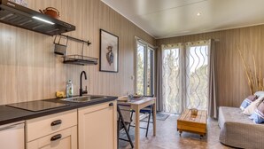 Una cocina moderna con estufa integrada, un lavaplatos y una zona de comedor con mesa y sillas.