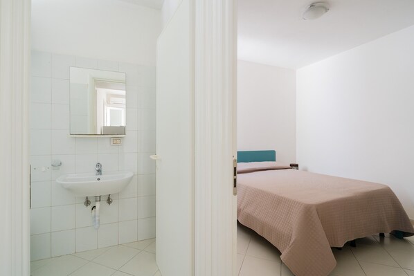 Une chambre à coucher avec un lit, une table de chevet et une fenêtre.