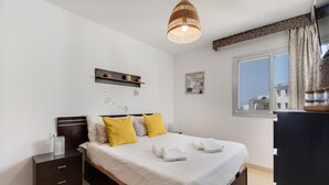A bedroom with a bed, bedside tables, a hanging light fixture, a window with curtains, and a wall-mounted shelf. - Vacation Apartment 'Apto Sol Paraiso Sunset View' with Shared Pool, Private Terrace and Wi-Fi (Adeje)