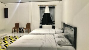 A hotel room with two beds, a small table with chairs, a window with curtains, and a painting on the wall. - Rinjani Terrace Cottage (Kotaraja)