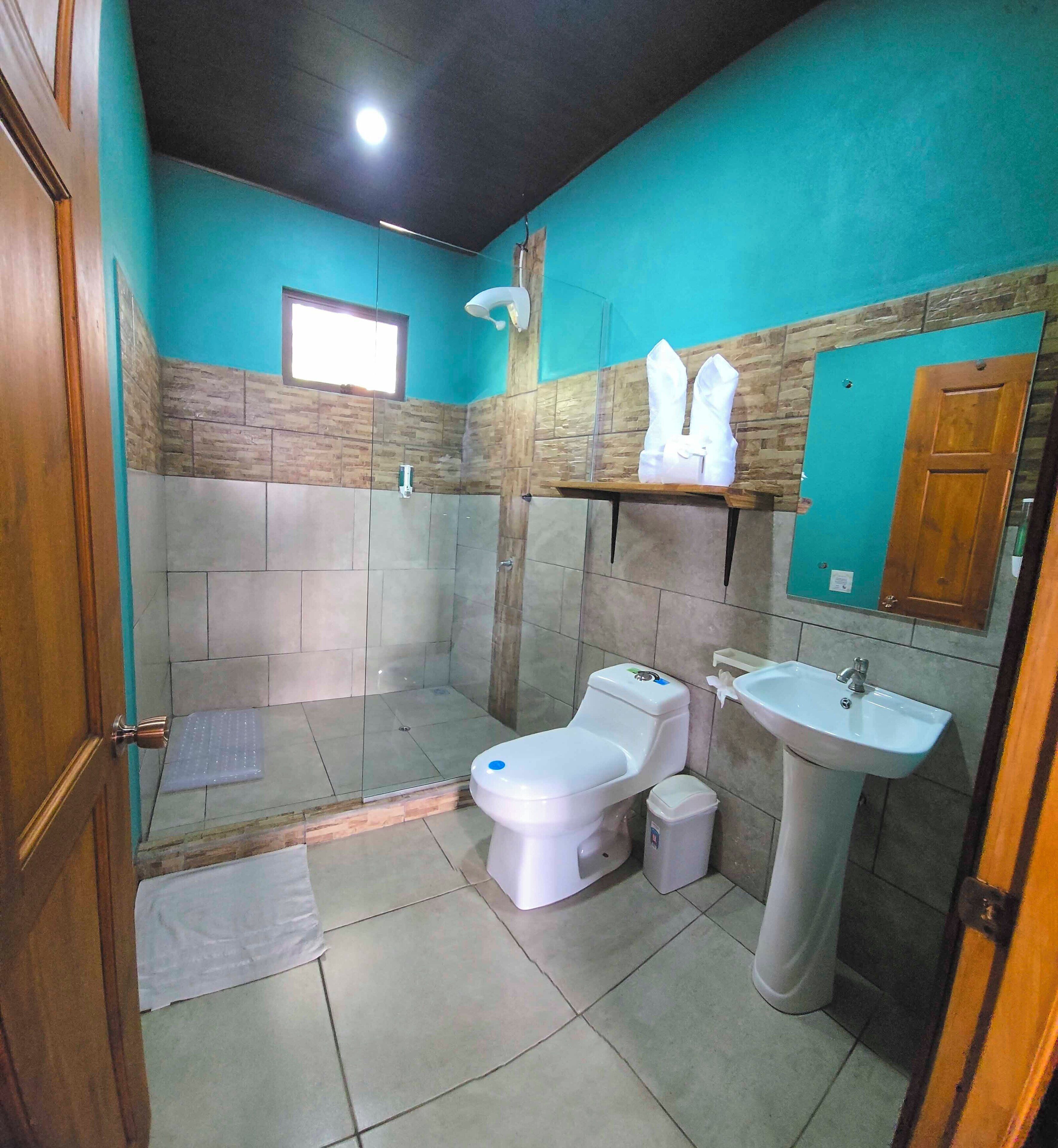 Un baño con ducha, inodoro y lavabo.
