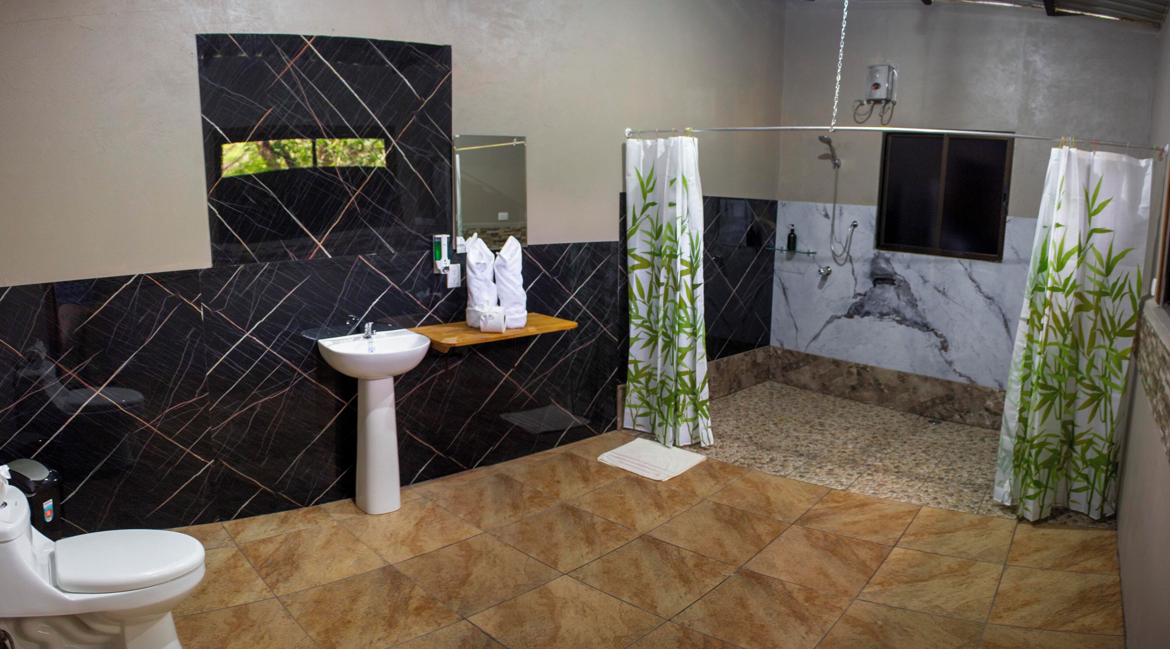 A bathroom with a sink, toilet, and shower area.