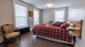 A bedroom with a bed, a chair, and a radiator. - ATLANTIC HOTEL (Alexandria)