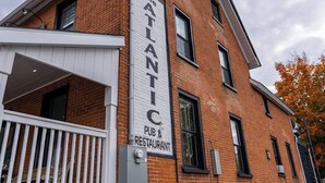 A brick building with a sign reading "The ATLANTIC PUB & RESTAURANT." - ATLANTIC HOTEL (Alexandria)