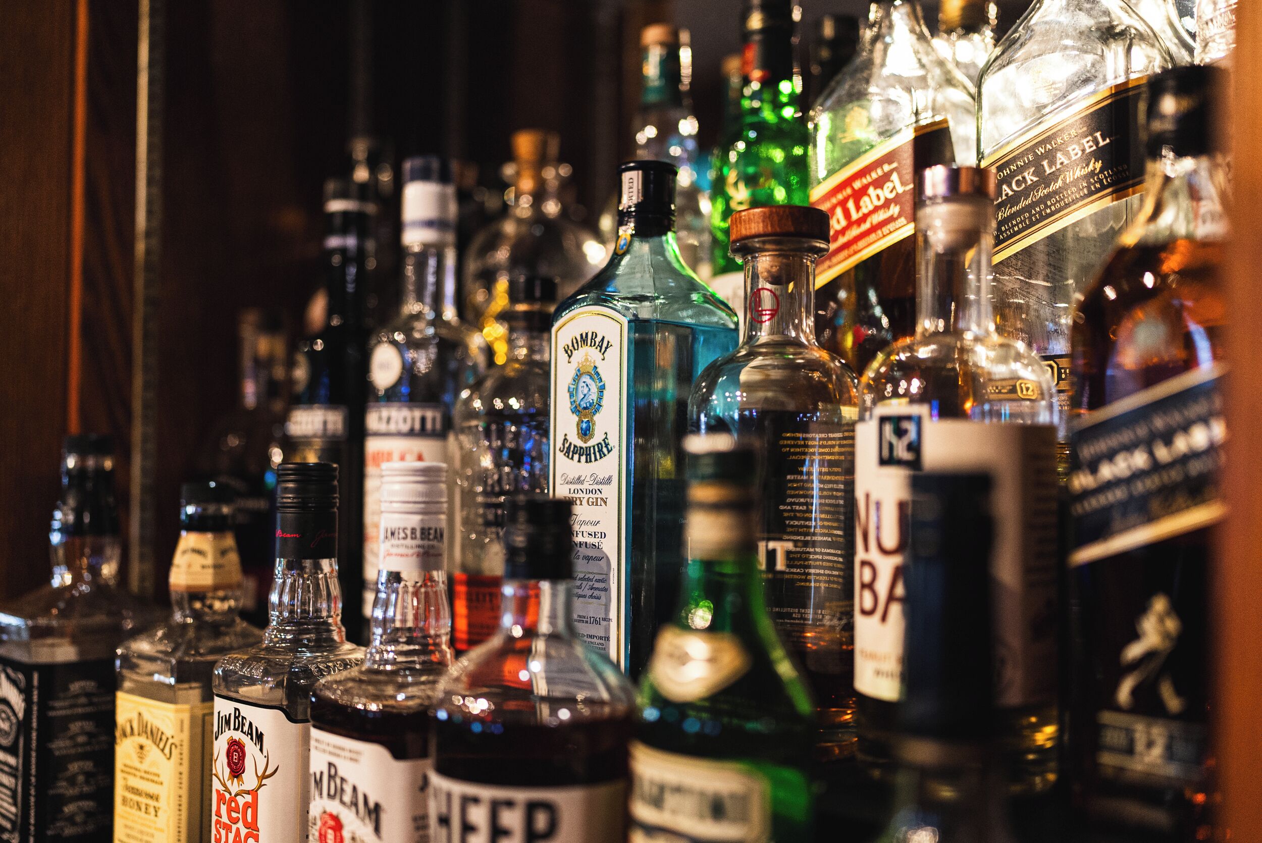 Variedad de botellas de licor en una estantería.