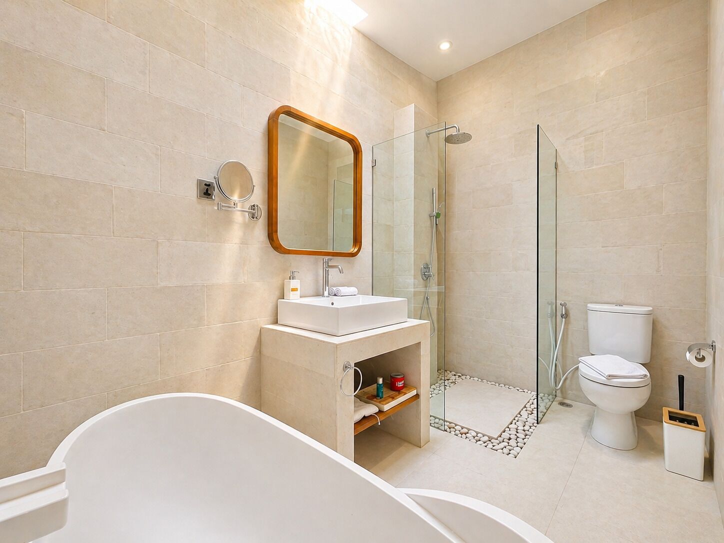 A modern bathroom with a freestanding bathtub, a glass-enclosed shower, a toilet, and a vanity with a mirror.