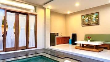 Relax by the pool in a spacious seating area with a sofa and coffee table.