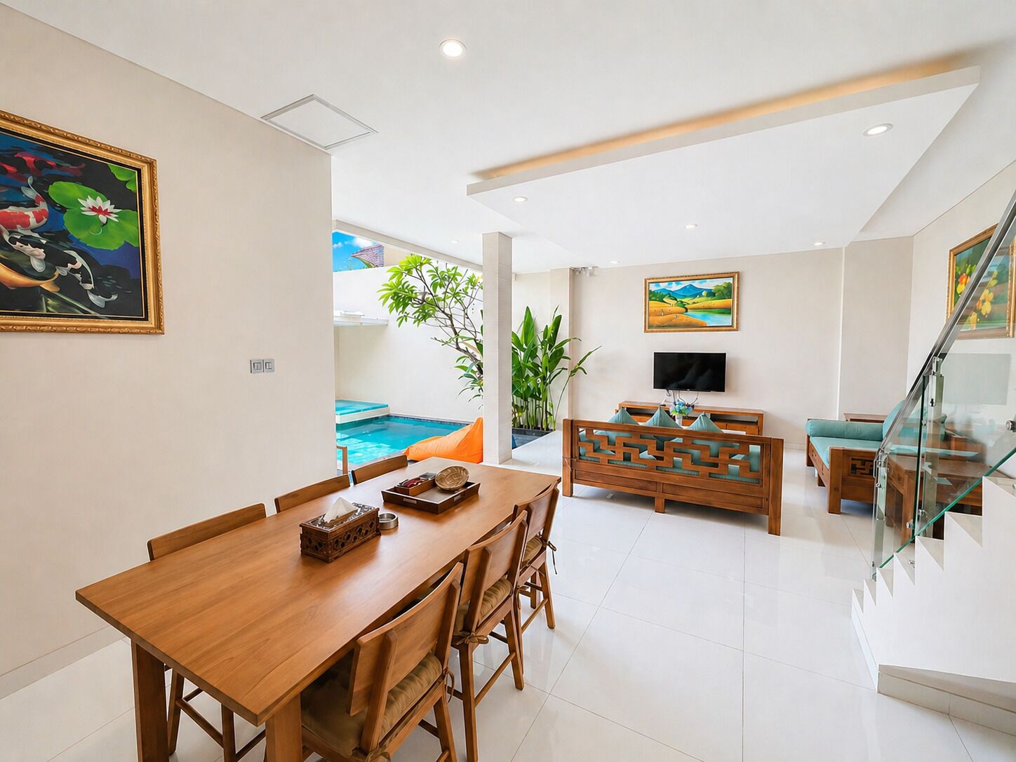 A modern living space with a dining area, a pool, and a staircase.