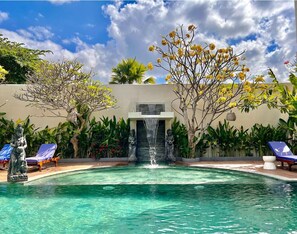 Una piscina al aire libre, tumbonas
