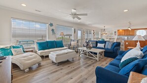 A spacious living room with a large sofa, a coffee table, and a dining area.