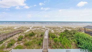 A staircase leading to a beach with a wooden walkway on either side.