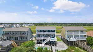 A coastal property with multiple buildings featuring balconies and a pool area.