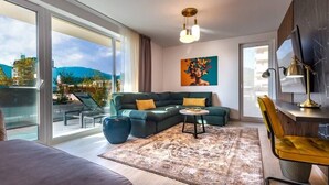 Un salon moderne avec un canapé, une table basse et un tableau accroché au mur.