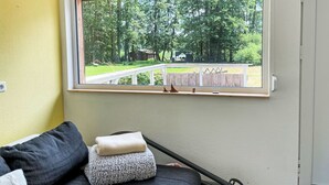 A room with a large window overlooking a green landscape, a bed with pillows, and a white wall. - am Pälitzsee by Interhome (Rheinsberg)