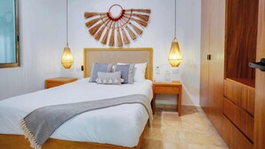 Une chambre à coucher avec un grand lit, deux tables de chevet, une armoire en bois et un élément décoratif fixé au mur.