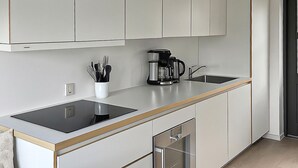 Eine moderne Küche mit einer eleganten Arbeitsplatte, einer Kaffeemaschine und einem Spülbecken.