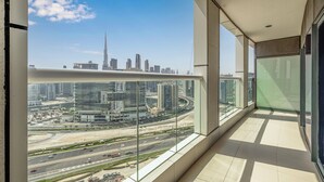 Ein Balkon mit Blick auf die Stadt, große Fenster und ein modernes Interieur.